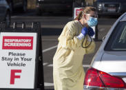 Physician assistant Nicole Thomas conducts a COVID-19 examination in the parking lot at Primary Health Medical Group's clinic in Boise, Idaho, Tuesday, Nov. 24, 2020. The urgent-care clinic revamped into a facility for coronavirus patients as infections and deaths surge in Idaho and nationwide. Some 1,000 people have died due to COVID-19, and infections this week surpassed 100,000. (AP Photo/Otto Kitsinger)