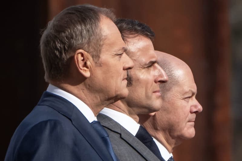 German Chancellor Olaf Scholz (R), Polish Prime Minister Donald Tusk (L) and French President Emmanuel Macron inspect a military honour guard at the Chancellery. The so-called Weimar Triangle top level meeting is taking place against the backdrop of massive Franco-German differences over Ukraine policy. Michael Kappeler/dpa