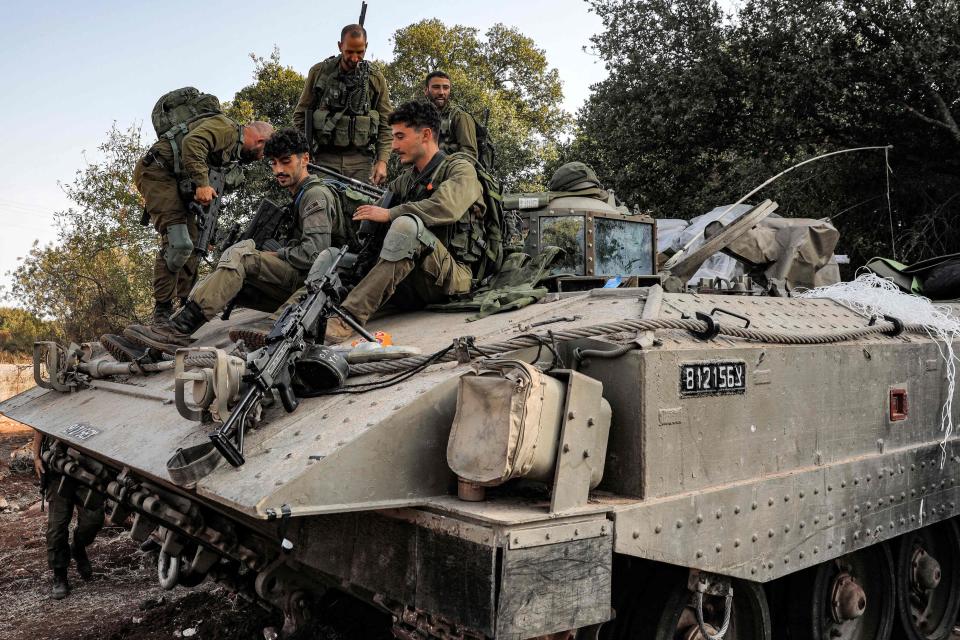 Israeli army soldiers sit atop a tracked vehicle at a position in the upper Galilee region of northern Israel near the border with Lebanon (AFP via Getty Images)