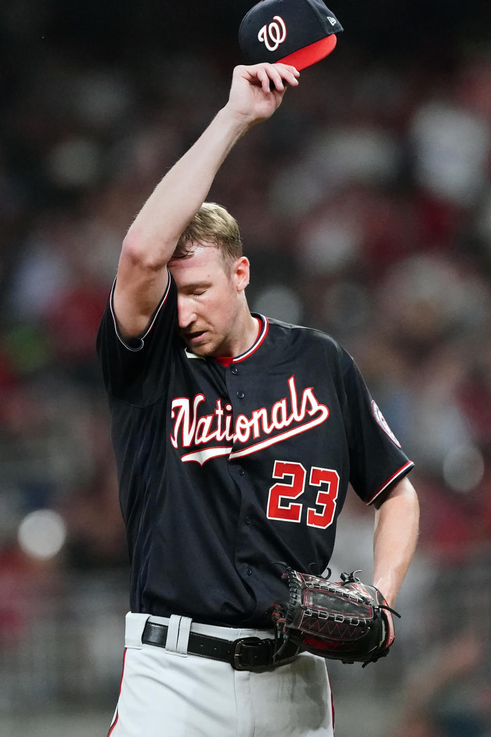 Washington Nationals pitcher Erick Fedde wipes his face as he waits for manager Dave Martinez to make his way to the mound for a pitching change in the fifth inning of a baseball game against the Atlanta Braves, Friday, Aug. 6, 2021, in Atlanta. (AP Photo/John Bazemore)