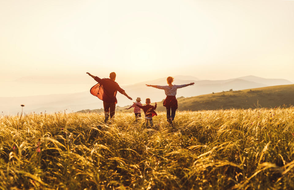 Happy family: mother, father, children son and  daughter runing and jumping on nature  on sunset