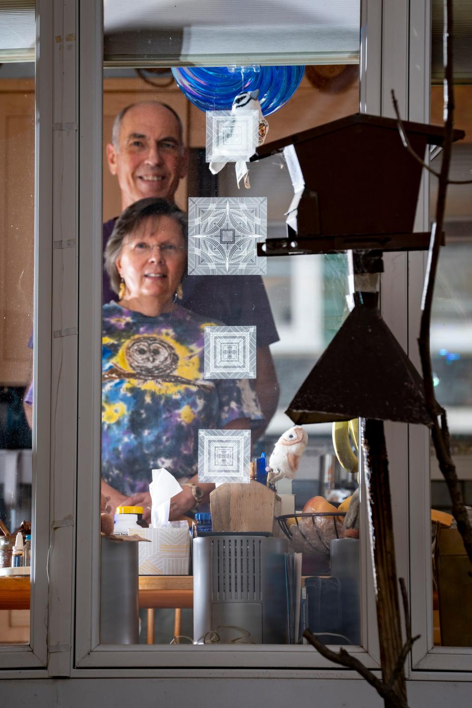 Sharon and Jeff Gustin stand for a portrait in their kitchen, where they watch and count birds outside the window.