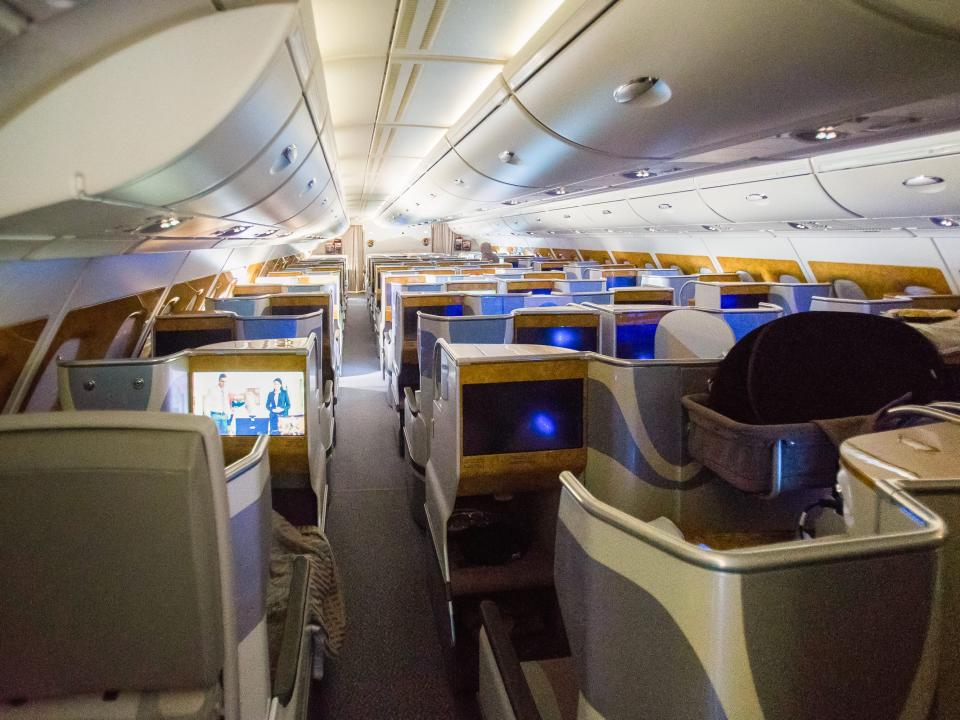 Inside a dark, business-class cabin with doors over the seats