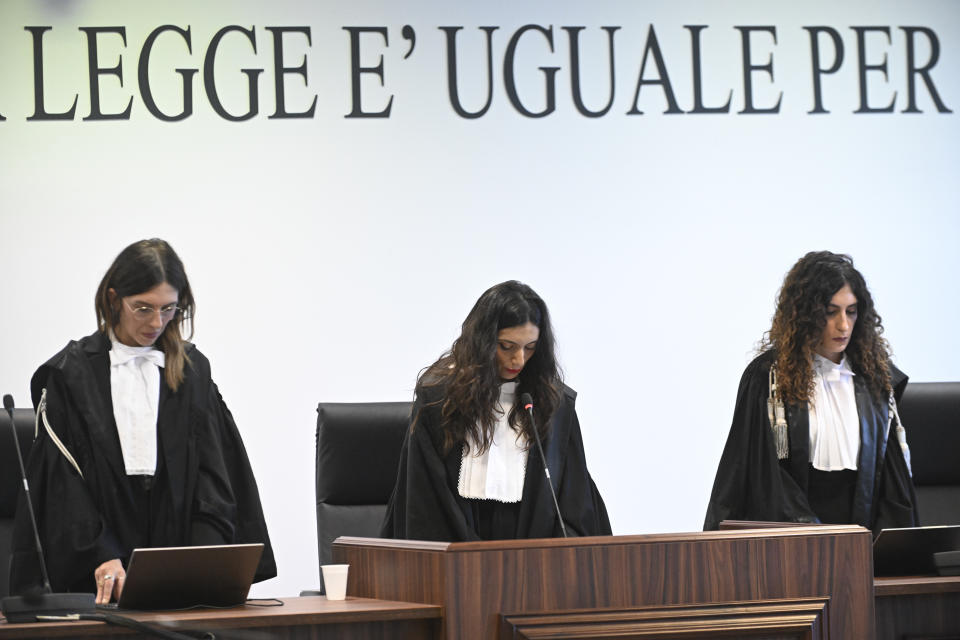 President of the court judge Brigida Cavasino, center, flanked by judges Claudia Caputo, left, and Germana Radice reads the verdicts of a maxi-trial of hundreds of people accused of membership in Italy's 'ndrangheta organized crime syndicate, one of the world's most powerful, extensive and wealthy drug-trafficking groups, in Lamezia Terme, southern Italy, Monday, Nov. 20, 2023. Verdicts are expected Monday for the trial that started almost three years ago in the southern Calabria region, where the mob organization was originally based. (AP Photo/Valeria Ferraro)