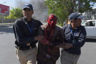 <p>Afghan men assist a wounded man at the site of a car bomb attack in Kabul on May 31, 2017. (Shah Marai/AFP/Getty Images) </p>