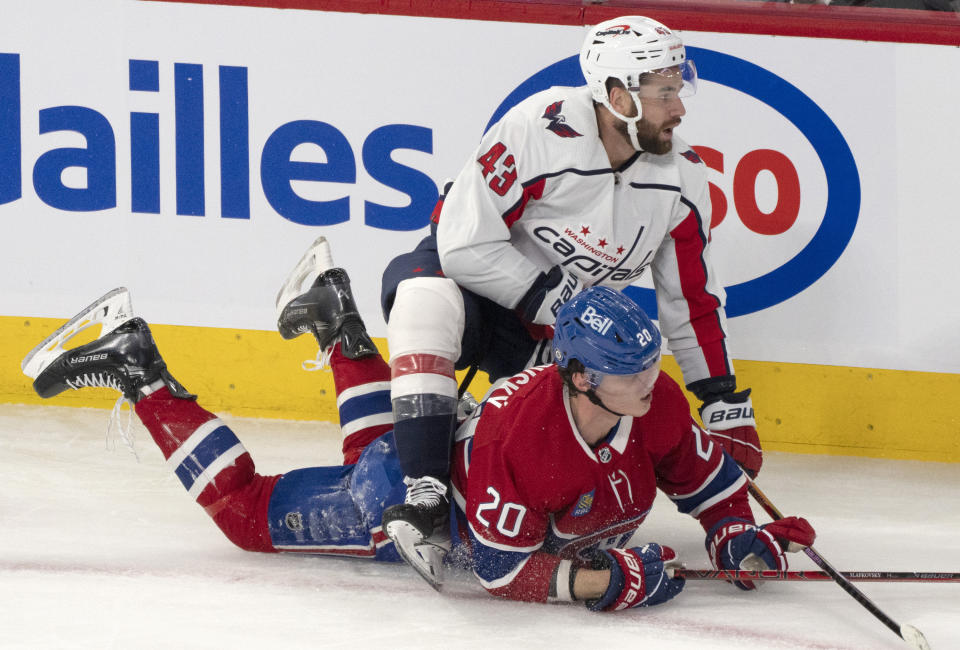 Montreal Canadiens' Juraj Slafkovsky (20) is checked by Washington Capitals' Tom Wilson (43) during the first period of an NHL hockey game in Montreal on Saturday, Oct. 21, 2023. (Christinne Muschi/The Canadian Press via AP)