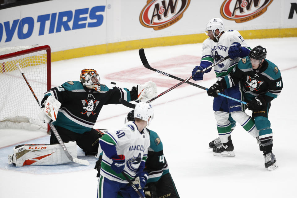 Anaheim Ducks goaltender Kevin Boyle, left, makes a save as teammate Josh Manson, right, and Vancouver Canucks' Josh Leivo watch during the third period of an NHL hockey game on Wednesday, Feb. 13, 2019, in Anaheim, Calif. The Ducks won 1-0. (AP Photo/Jae C. Hong)