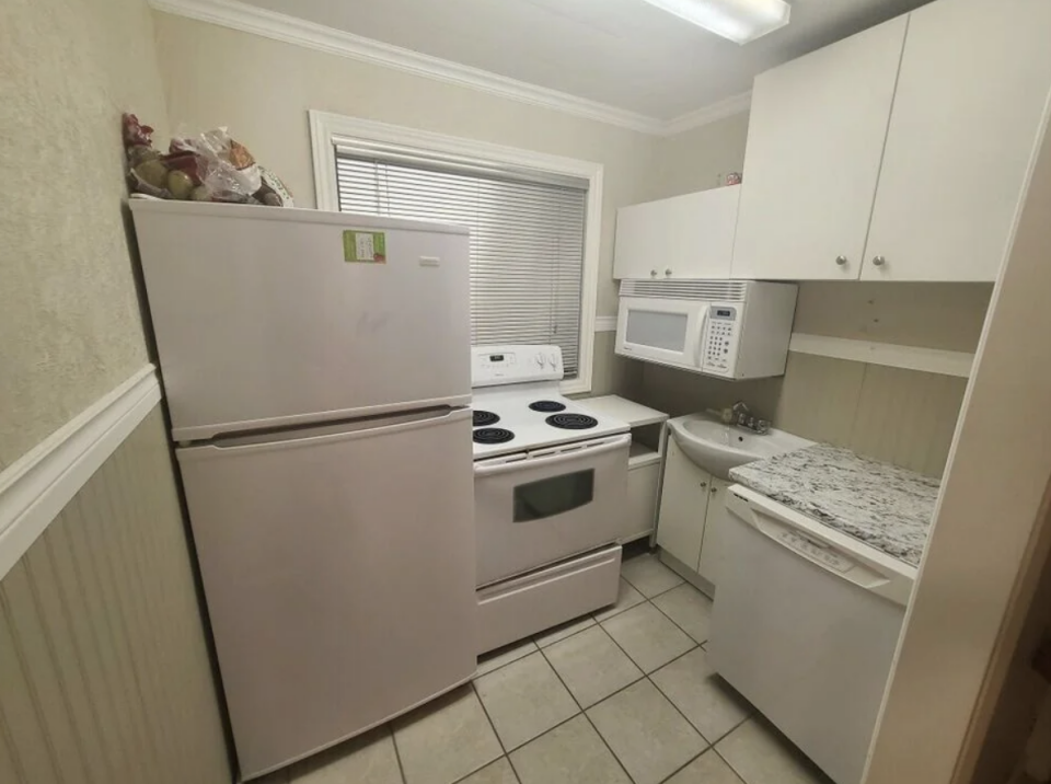 Small kitchen with refrigerator, stove, microwave and washing machine