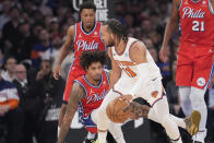 New York Knicks guard Jalen Brunson (11) drives against Philadelphia 76ers guard Kelly Oubre Jr., bottom center, and guard Kyle Lowry, back left, during the first half in Game 1 of an NBA basketball first-round playoff series, Saturday, April 20, 2024, at Madison Square Garden in New York. (AP Photo/Mary Altaffer)