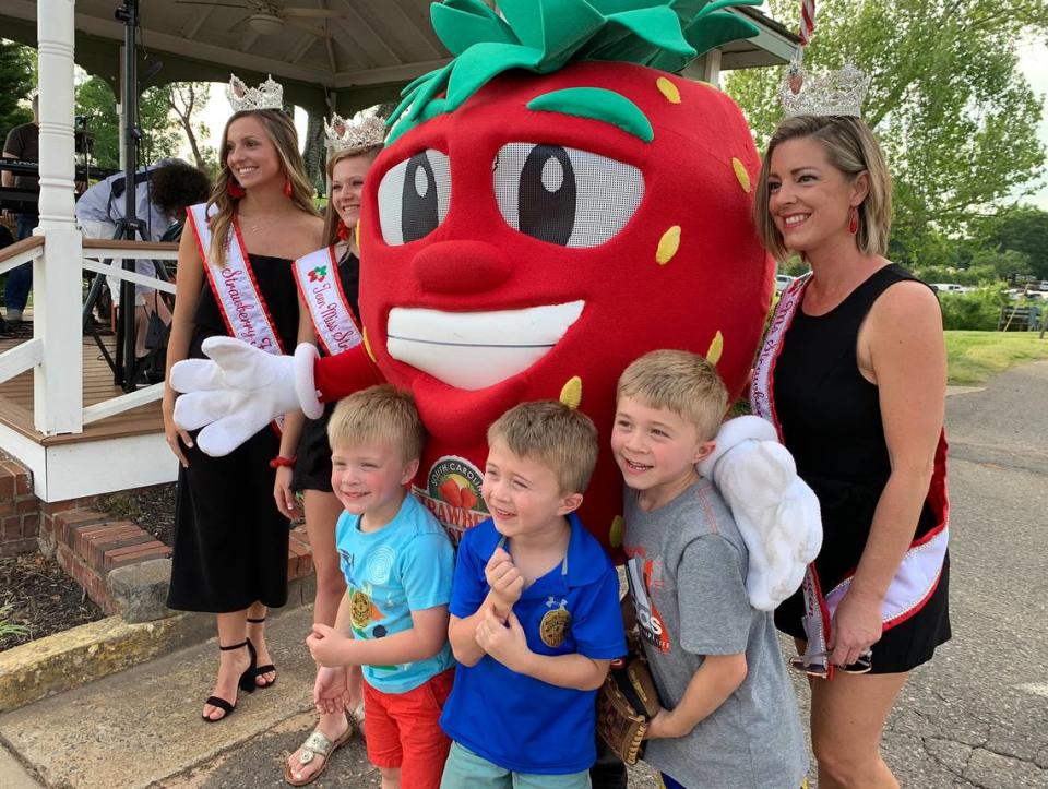 In 2019, little boys pose with beauty queens and a strawberry Wednesday evening at the Main Street Fort Mill Strawberry Jam as part of the 10th annual Strawberry Festival.