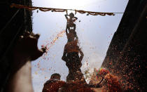 <p>Curd spills as Indian devotees form a human pyramid and break the “Dahi handi”, an earthen pot filled with curd, as part of celebrations to mark Janmashtami in Mumbai, India, Aug. 25, 2016. The holiday marks the birth of Hindu god Krishna. (Photo: Rafiq Maqbool/AP) </p>