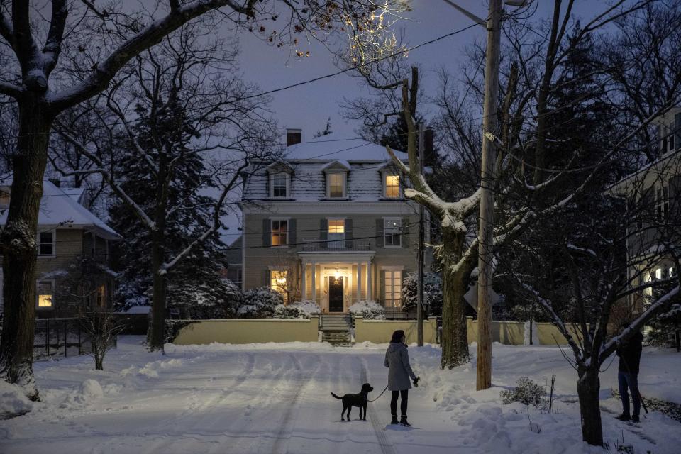 Neighbors stop and talk while out at dusk following a snowfall Sunday, Jan. 7, 2024, in Providence, R.I. A major winter storm bringing heavy snow and freezing rain to some communities spread across New England on Sunday morning, sending residents scurrying to pull out their shovels and snowblowers to clear sidewalks and driveways. (AP Photo/David Goldman)