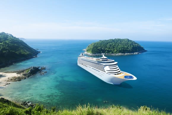 A cruise ship docked near an island.