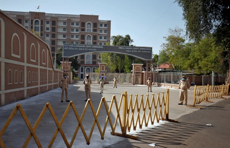 Policemen stand outside a closed court after the lockdown by Gujarat state government to limit the spreading of coronavirus disease (COVID-19), in Ahmedabad