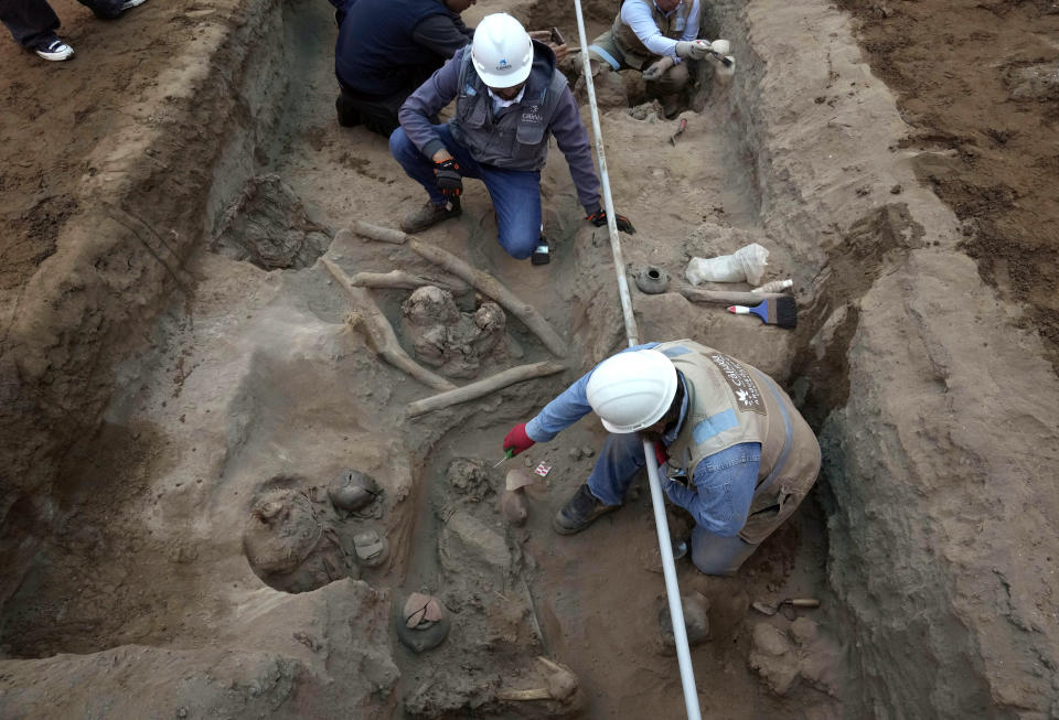 Arqueólogos descubren huesos y vasijas halladas por trabajadores de la ciudad que estaban cavando una tubería de gas natural para la empresa Calidda en el distrito de Carabayllo en las afueras de Lima, Perú, el viernes 22 de septiembre de 2023. (AP Foto/Martín Mejía)