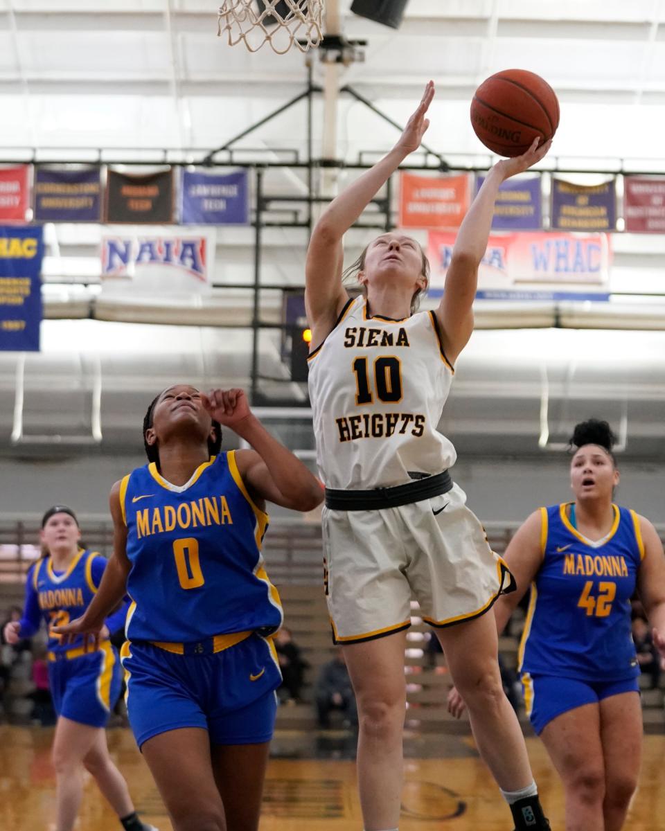 Olvia DeLong of Siena Heights scores inside against Madonna’s JayCee’anna Anderson during a 79-27 Siena Heights win Wednesday night.