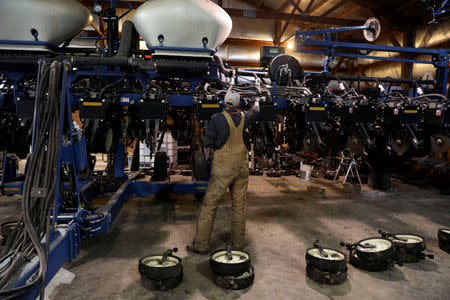 Luke Waddington, the hired hand of farmer Austin Rincker, looks over a planter component as the unit is prepared for the spring planting season in Moweaqua, Illinois, U.S., March 6, 2019. Rincker will farm approximately 2500 acres in the upcoming season, split evenly between corn and soybeans. Picture taken March 6, 2019. REUTERS/Daniel Acker