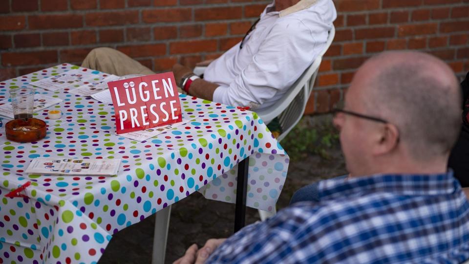 Sitzt hier die «Lügenpresse»? Zwei Männer auf dem Gelände des Neonazi-Festivals «Schild und Schwert». Foto: dpa