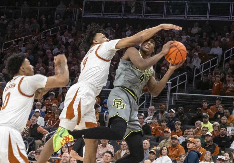 Baylor guard Ja'Kobe Walter, right, goes up for a shot against Texas guard Ithiel Horton, center, and Chris Johnson, left, during the first half of an NCAA college basketball game, Saturday, Jan. 20, 2024, in Austin, Texas. (AP Photo/Michael Thomas)