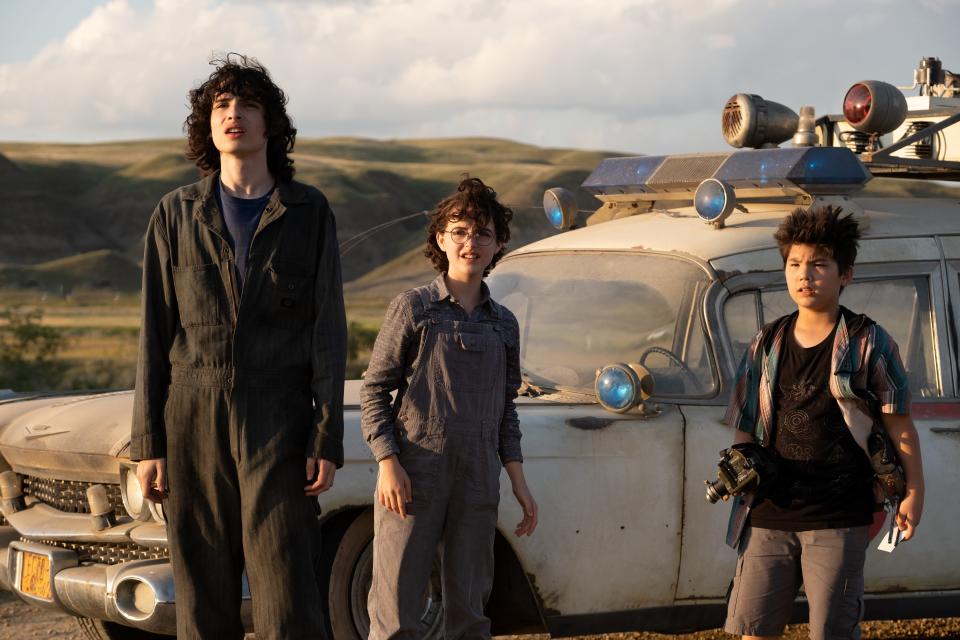 Trevor (Finn Wolfhard, from left), Phoebe (Mckenna Grace) and Podcast (Logan Kim) rev up the Ecto-1 and fight back against dark forces in a small Oklahoma town in "Ghostbusters: Afterlife."