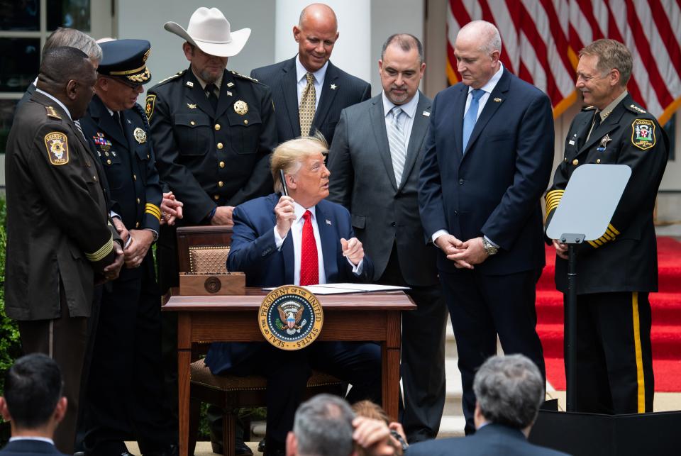 US President Donald Trump offers pens after signing an Executive Order on Safe Policing for Safe Communities, in the Rose Garden of the White House in Washington, DC, June 16, 2020. (Photo by SAUL LOEB / AFP) (Photo by SAUL LOEB/AFP via Getty Images)