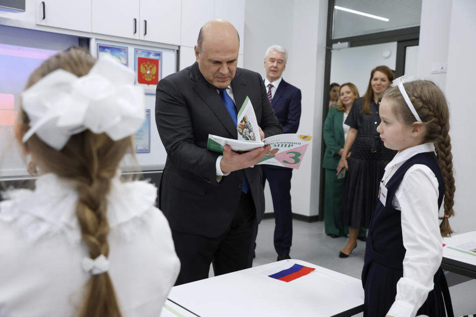 Russian Prime Minister Mikhail Mishustin, accompanied by Moscow Mayor Sergei Sobyanin, visits the secondary school No 1579 on the first day of the new academic year in Moscow, Russia, Friday, Sept. 1, 2023. (Dmitry Astakhov, Sputnik, Kremlin Pool Photo via AP)