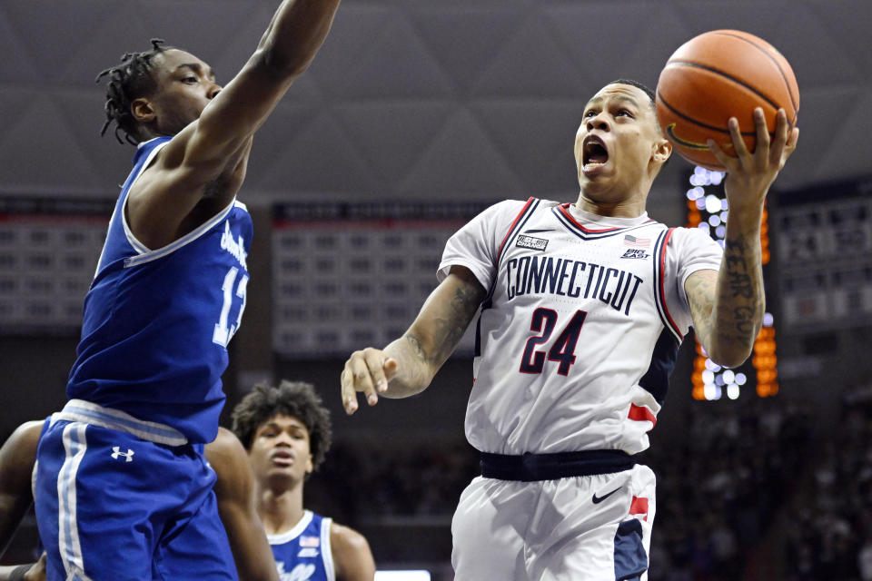 UConn's Jordan Hawkins (24) goes up to the basket as Seton Hall's KC Ndefo (13) defends in the second half of an NCAA college basketball game, Saturday, Feb. 18, 2023, in Storrs, Conn. (AP Photo/Jessica Hill)