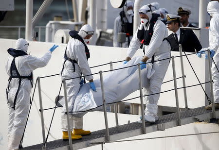 Italian coastguard personnel in protective clothing carry the body of a dead immigrant off their ship Bruno Gregoretti in Senglea, in Valletta's Grand Harbour April 20, 2015. REUTERS/Darrin Zammit Lupi