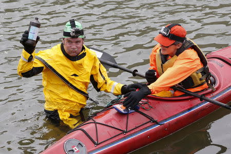 Christopher Swain, a clean-water activist, gargles with hydrogen peroxide after swimming in the Gowanus Canal as part of an Earth Day awareness action about pollution in the Brooklyn borough of New York April 22, 2015. REUTERS/Shannon Stapleton