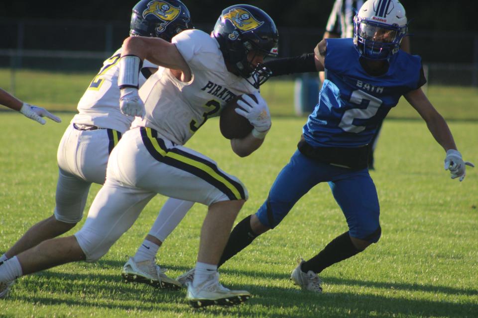 Pewamo-Westphalia junior running back Brayton Thelen (No. 3) carries the ball while Bath junior defensive back Jay Kreisler looks to tackle him during a varsity football game Thursday, Aug. 31, at Bath High School. P-W won the game, 21-0.