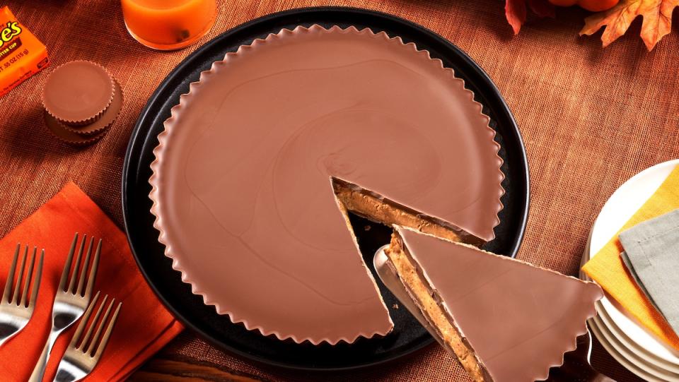 The biggest Reese's Peanut Butter Cup ever sold on a table and having a slice removed like it's a pie