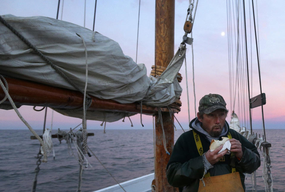 In this Dec. 20, 2013 picture, Danny Benton eats breakfast before a day of oyster dredging aboard the skipjack Hilda M. Willing in Tangier Sound near Deal Island, Md. (AP Photo/Patrick Semansky)