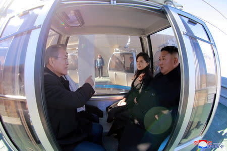 South Korean President Moon Jae-in, North Korean leader Kim Jong Un and his wife Ri Sol Ju sit inside a cable car at Mt. Paektu, North Korea, in this photo released by North Korea's Korean Central News Agency (KCNA) on September 21, 2018. KCNA via REUTERS