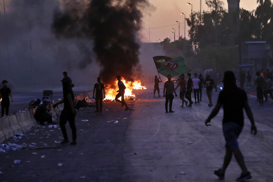 Anti-government protesters set fires and close a street during a demonstration in Baghdad, Iraq, Friday, Oct. 4, 2019. Security forces opened fire directly at hundreds of anti-government demonstrators in central Baghdad, killing some protesters and injuring dozens, hours after Iraq's top Shiite cleric warned both sides to end four days of violence "before it's too late." (AP Photo/Khalid Mohammed)