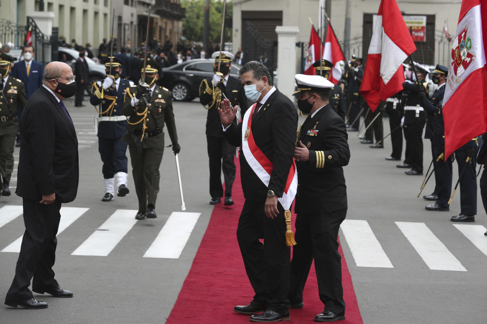 A military aide shows the way to Manuel Merino, the head of Peru's legislature, after he was sworn-in as Peru's new president, replacing Martín Vizcarra who was removed by lawmakers the previous night, in Lima Peru, Tuesday, Nov. 10, 2020. Congress voted to oust Vizcarra over his handling of the new coronavirus pandemic and unproven allegations of corruption years ago. (AP Photo/Martin Mejia)