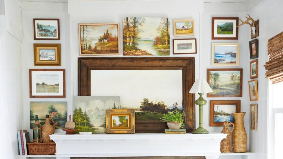 art gallery wall surrounding fireplace in nook with two club chairs upholstered in blue and white ticking fabric in a 1920s bungalow in west virginia