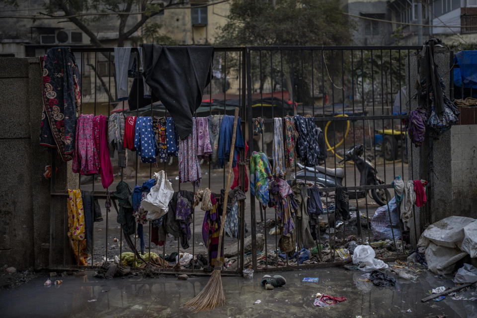 Clothes hang on the iron gate of a dilapidated shelter for homeless people in New Delhi, Friday, Dec. 30, 2022. India’s 2011 census figures show about 47,000 of the city’s residents were sleeping homeless, but activists say the number is a vast underestimate and that New Delhi has more than 150,000 rough sleepers. (AP Photo/Altaf Qadri)