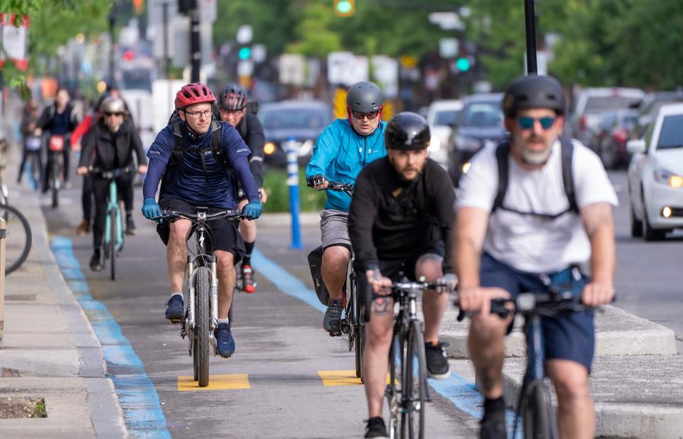Cyclists make their way down St-Denis Street in Montreal. Quebec City hopes to build a network of cycling paths within the next 10 years to offer more choice to commuters. (Paul Chiasson/The Canadian Press - image credit)