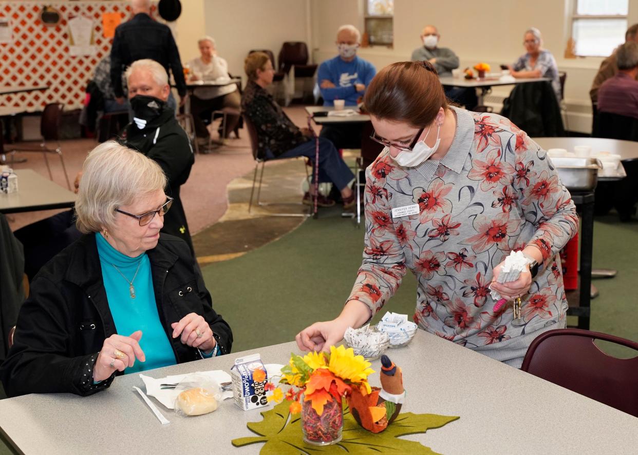 Jennifer Perry, right, director of the Adrian Senior Center, waits on Barbara Bates of Palmyra Thursday during the senior center's annual community Thanksgiving dinner, which returned this year after being held in a drive-thru format last year.