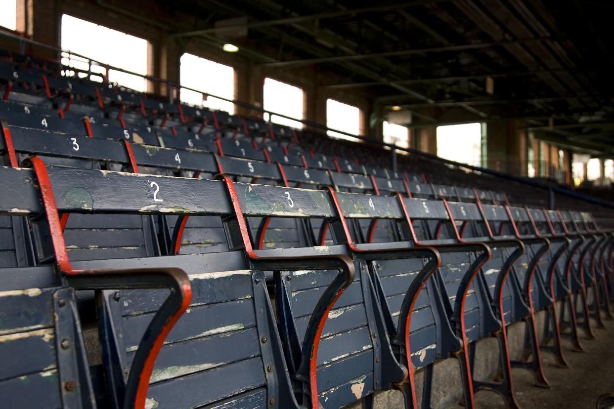 A group of old stadium seats with an awning in the background.