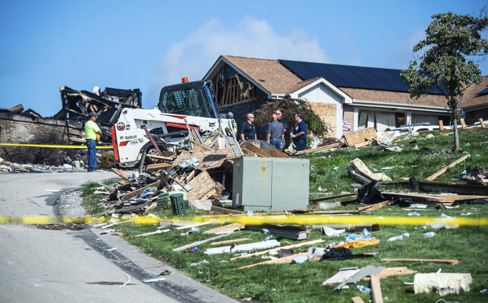 Investigators remain at the scene of the home explosion. Source: AP