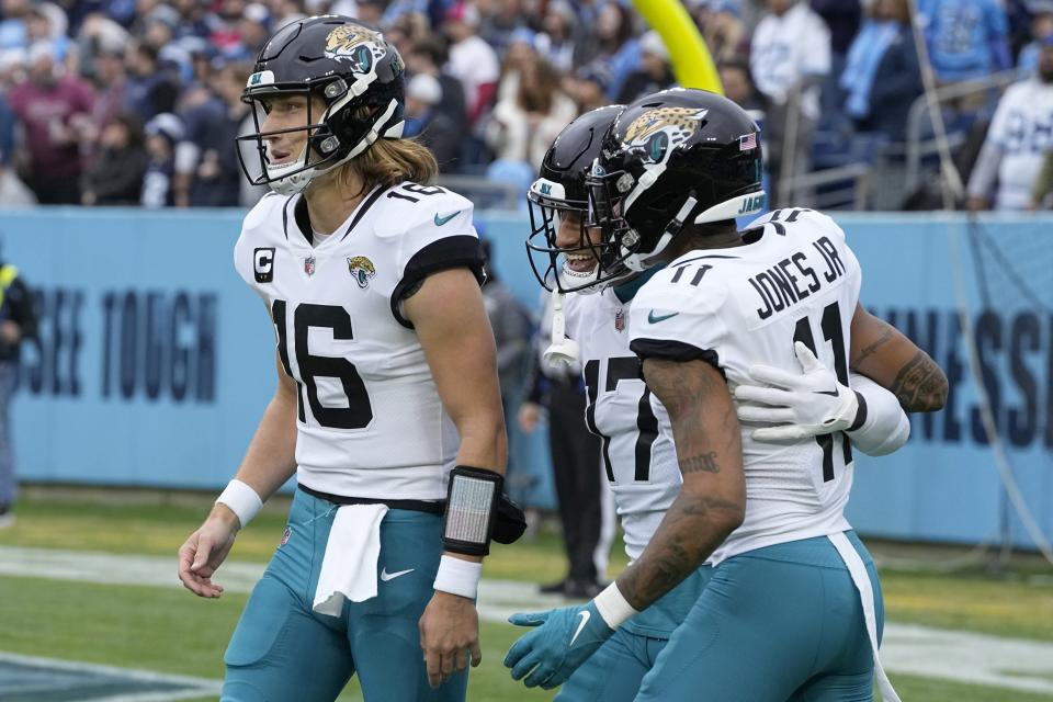 Jacksonville Jaguars tight end Evan Engram (17) is congratulated by teammates Trevor Lawrence (16) and Marvin Jones Jr. (11) after scoring during the first half of an NFL football game against the Tennessee Titans Sunday, Dec. 11, 2022, in Nashville, Tenn. (AP Photo/Chris Carlson)