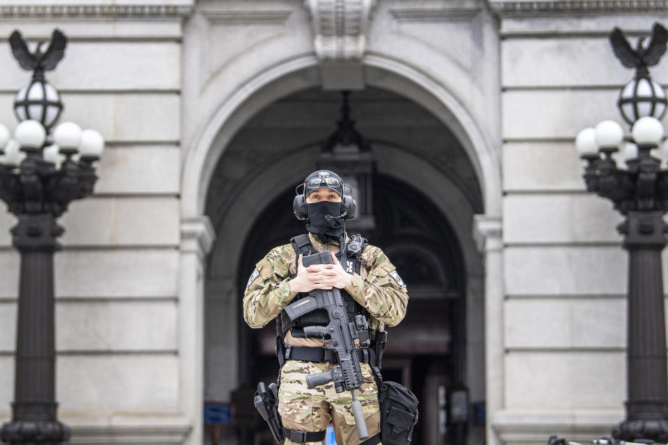 A member of the Pennsylvania Capitol Police guards the entrance to the Pennsylvania Capitol Complex in Harrisburg, Pa. Wednesday, Jan. 13, 2021. State capitols across the country are under heightened security after the siege of the U.S. Capitol last week. (Jose F. Moreno/The Philadelphia Inquirer via AP)