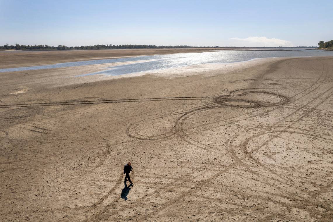 In this photo taken by a drone, James Isaacks walks where the normally wide Mississippi River would flow Thursday, Oct. 20, 2022, near Portageville, Mo. The lack of rainfall in recent weeks has left the river approaching record low levels in areas from Missouri south through Louisiana, disrupting barge and other travel along the river.