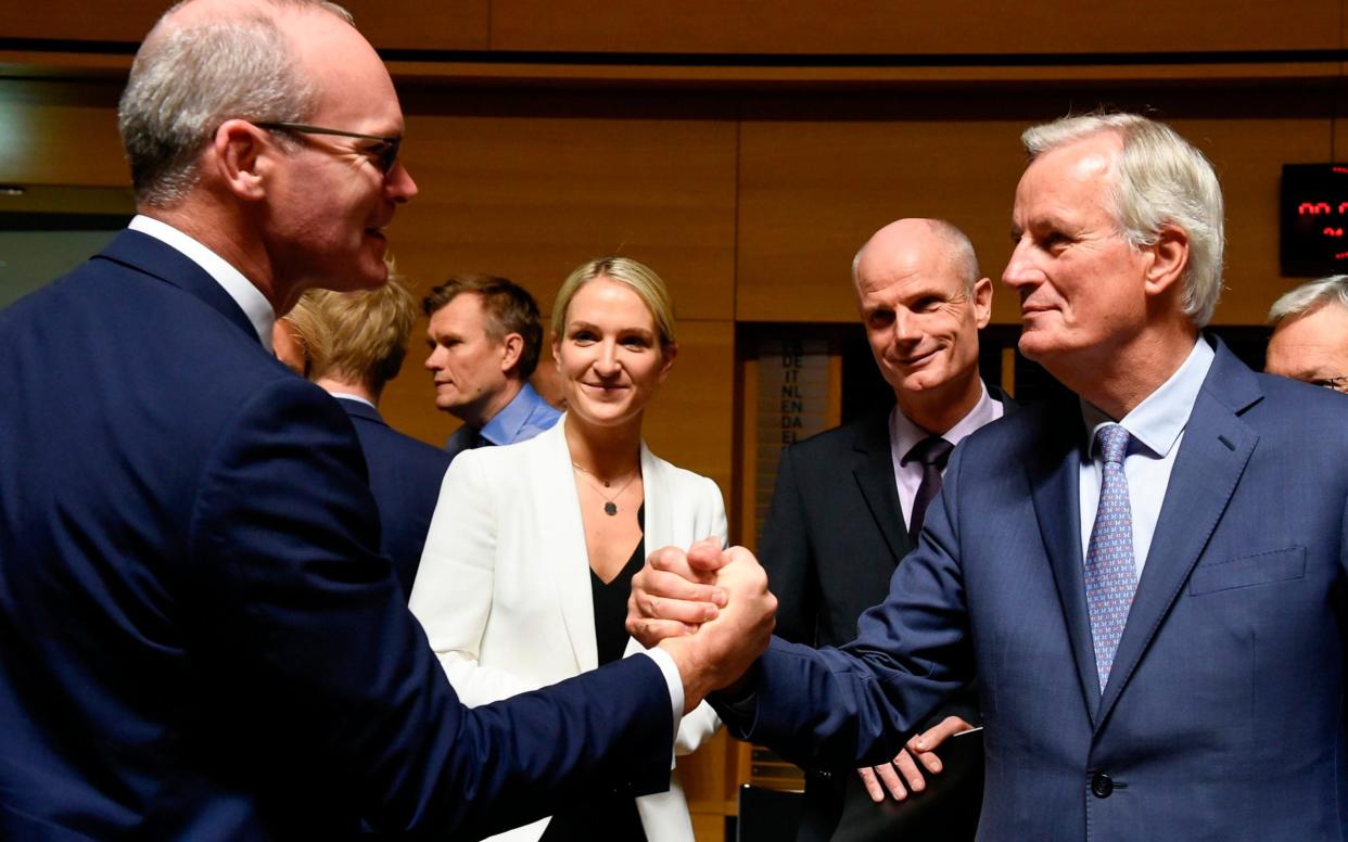 Simon Coveney greets Michel Barnier last year.  - AFP
