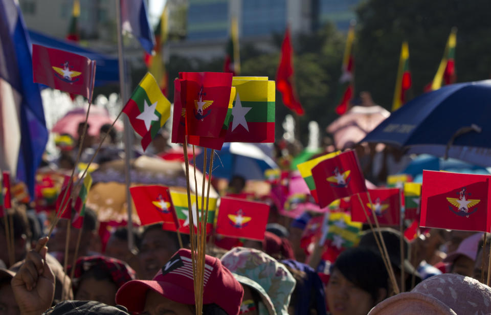 Supporters hold flags of Myanmar National and military during a pro-military rally Sunday, Oct. 14, 2018, in front of city hall in Yangon, Myanmar. Several thousand pro-military and nationalist demonstrators marched through Yangon on Sunday voicing their support for Myanmar's armed forces and government while condemning foreign involvement in the country's affairs. (AP Photo/Thein Zaw)