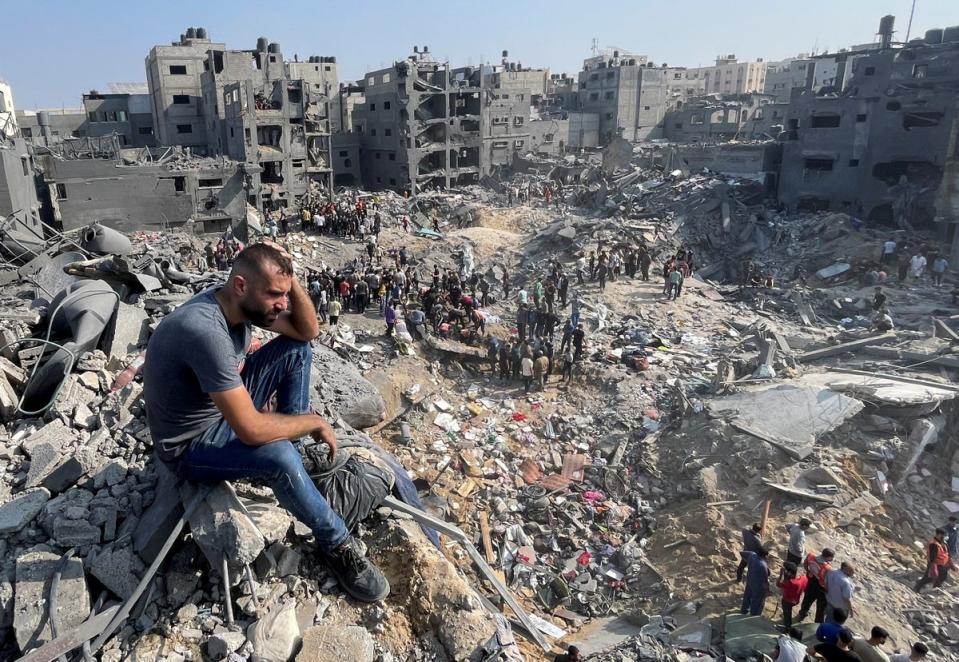 A man gestures as Palestinians search for casualties a day after Israeli strikes on houses in Jabalia refugee camp (Reuters)