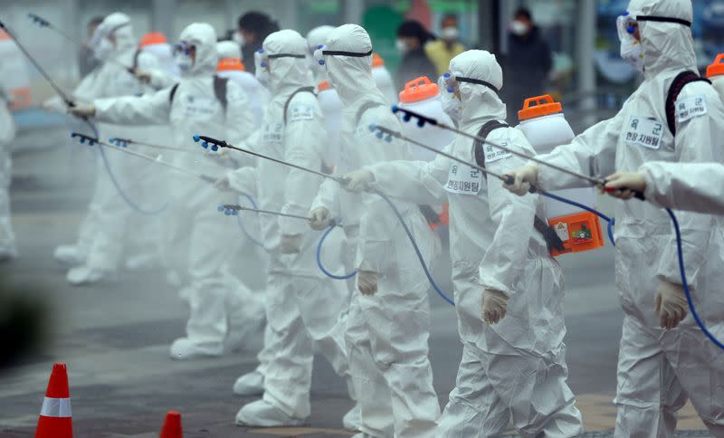 South Korean soldiers wearing protective gear sanitize Daegu railway station in Daegu