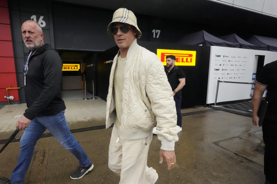 Brad Pitt walks in the paddock at the Silverstone racetrack, Silverstone, England, Friday, July 5, 2024. Brad Pitt's movie about Formula 1 coming to cinemas next year will simply be called "F1," the racing series said Friday. Seven-time F1 champion Lewis Hamilton is a co-producer of the project, which collected footage at several F1 circuits around the world this year and last. (AP Photo/Luca Bruno)