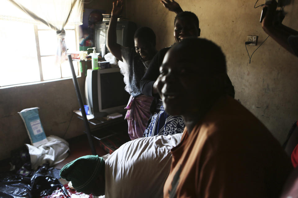 Women celebrate after a baby is delivered in a tiny apartment in the poor surburb of Mbare in Harare, Zimbabwe, Saturday, Nov. 16, 2019, with the help of 72-year old grandmother Esther Zinyoro Gwena. Grandmother Esther Zinyoro Gwena claims to be guided by the holy spirit and has become a local hero, as the country’s economic crisis forces closure of medical facilities, and mothers-to-be seek out untrained birth attendants.(AP Photo/Tsvangirayi Mukwazhi)